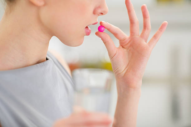 istock Closeup on young housewife eating pill 451969307