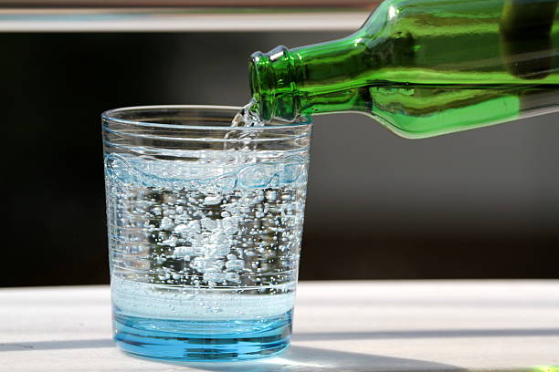Pouring mineral water in the glass Pouring cold mineral water in the glass close up image. carbonated water photos stock pictures, royalty-free photos & images