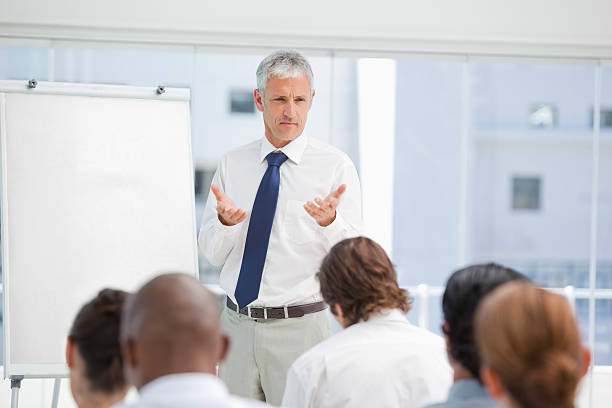 istock Serious businessman gesturing towards his colleagues with both h 451993465