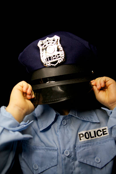 istock Little boy dressed up as policeman with hat covering head. 451994429