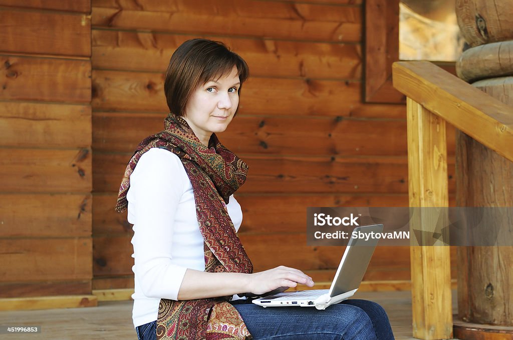 Woman with laptop Woman with laptop sitting on wooden porch Accessibility Stock Photo