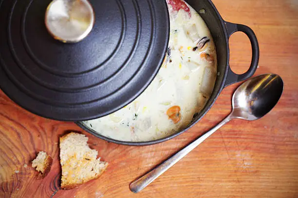 Photo of Clam chowder with sausage and potatoes in iron casserole