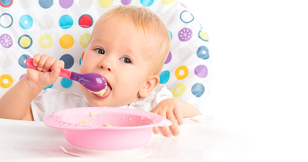 istock happy baby child eats itself with a spoon 452017745