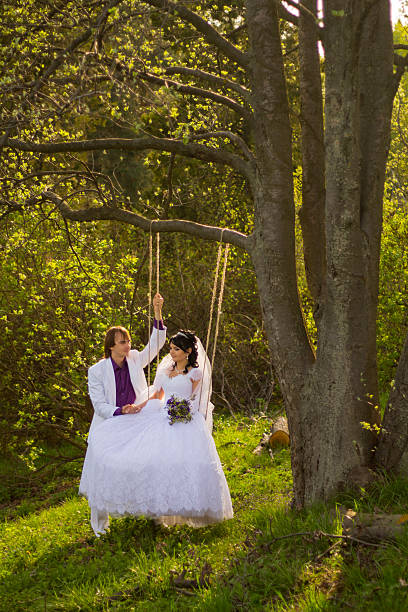 istock bride and groom swinging on a swing 452018739