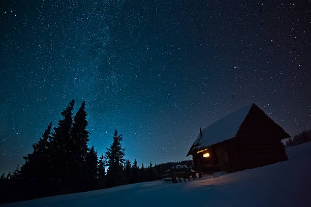 istock Lonely house covered in snow among forest at night 452029739