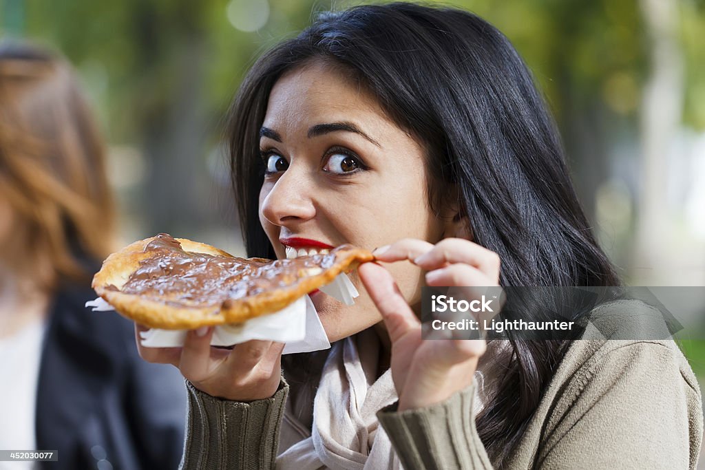 Girl Nibbling Chocolate Scone Pretty hungry girl nibbling a chocolate scone. Adult Stock Photo