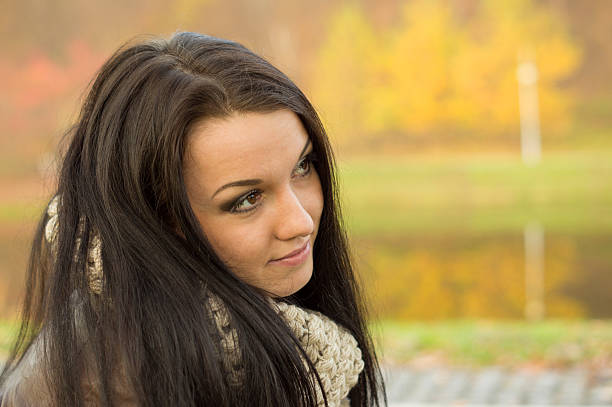 istock Young pretty woman in autumn park 452030493