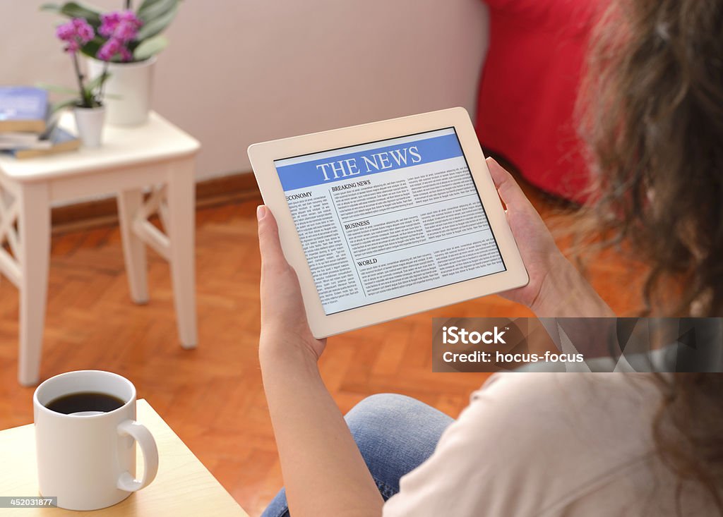 Reading news on tablet pc Woman reading news on tablet pc. Adult Stock Photo