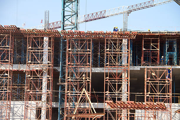 istock Crane and workers at construction site against blue sky. Thailand 452041955