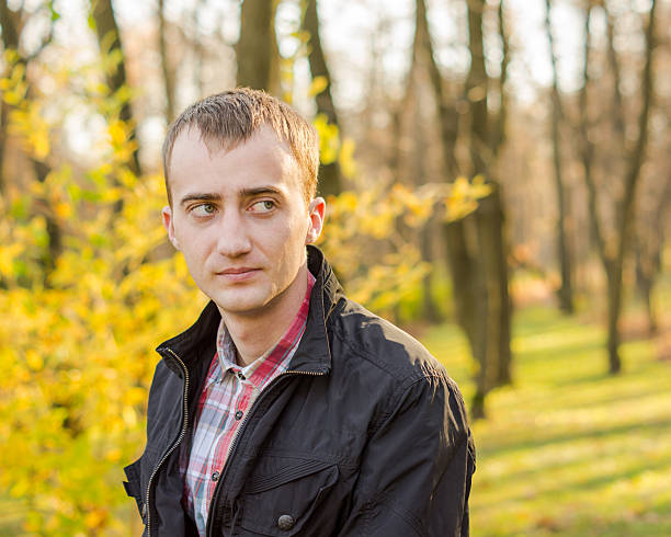 istock Young handsome man in autumn park 452043781