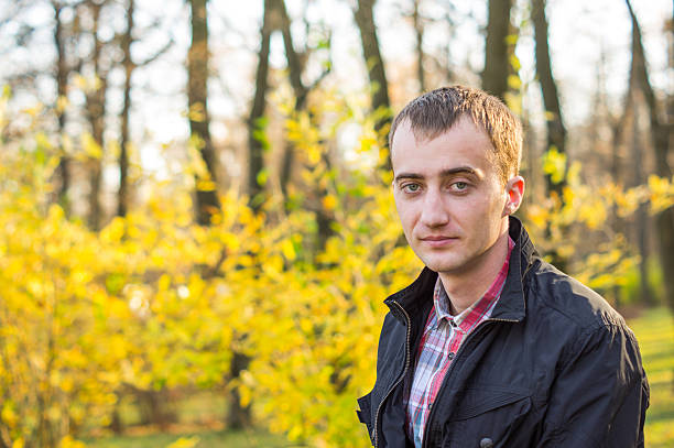 istock Young handsome man in autumn park 452043791