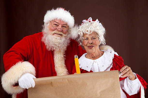 Santa e Mrs Claus scrivere sulla sexy bella elenco - foto stock