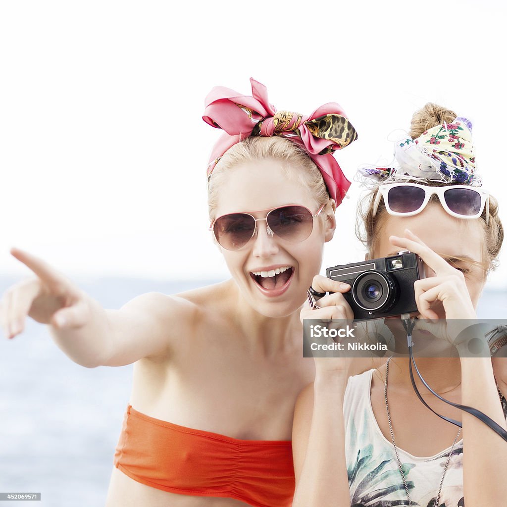 Due belle ragazze al molo di mare - Foto stock royalty-free di Abbigliamento casual