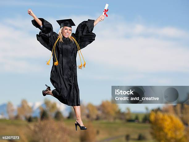 Jumping Beautiful Female School Graduate Stock Photo - Download Image Now - Arms Raised, Freedom, Graduation