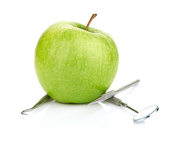 istock Green apple and dental tools isolated on white 452078747