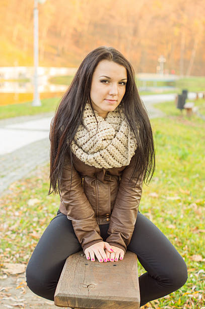 istock girl sitting on bench outdoors 452080831