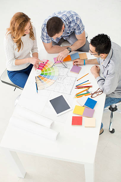 istock Young Architects review blueprints at office. 452092289