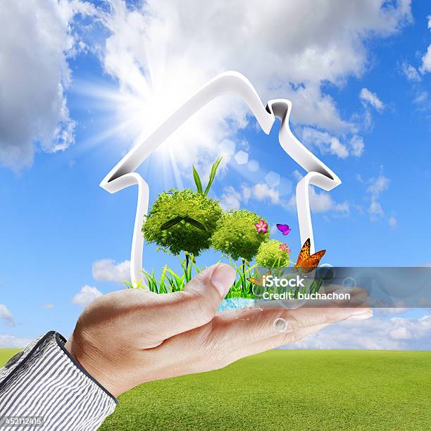 Human Hand Shows A Green House Concept Stock Photo - Download Image Now - Aspirations, Backgrounds, Blue