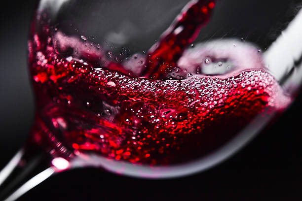Red wine Red wine in wineglass on  black background foam material photos stock pictures, royalty-free photos & images