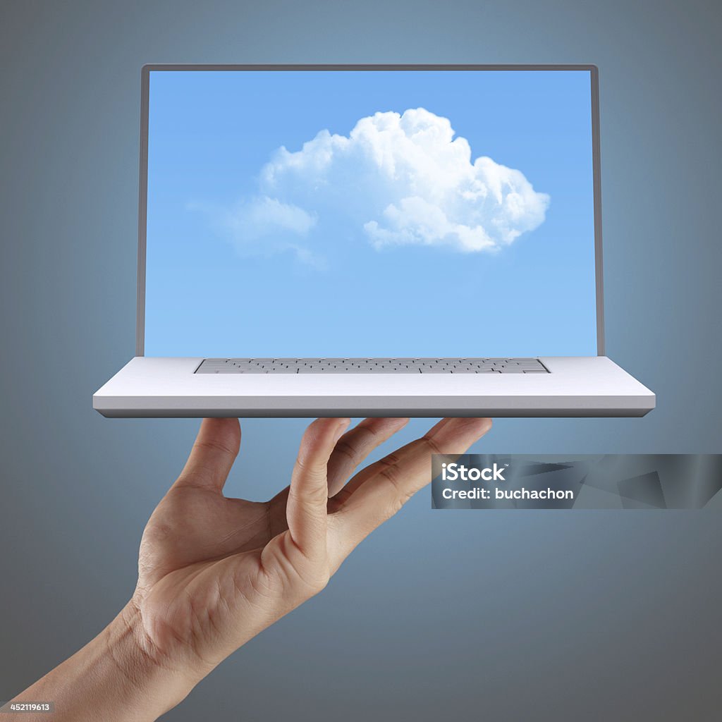 Cloud computing concept hand shows cloud computing, laptop in front of virtual cloud. Accessibility Stock Photo