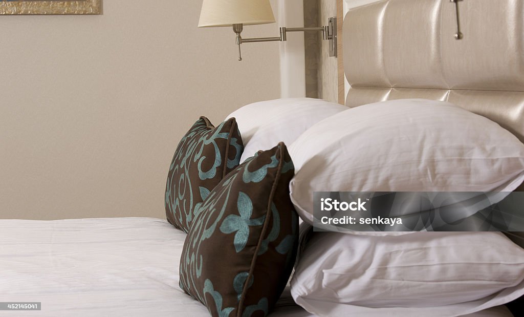 Cama King-size em um quarto de hotel de luxo - Foto de stock de Cabeceira royalty-free