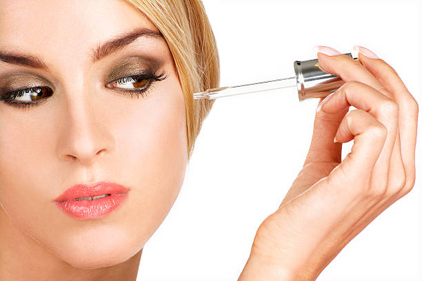 istock beautiful model applying a skin serum treatment 452154915