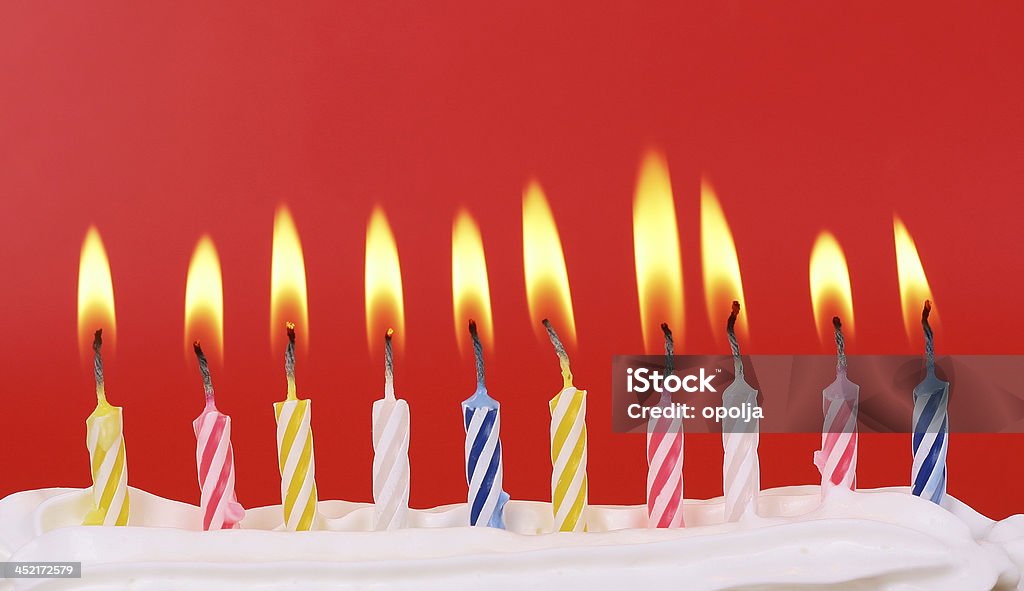 Diez iluminada con velas de cumpleaños en colores brillantes con fondo rojo - Foto de stock de 10-11 años libre de derechos