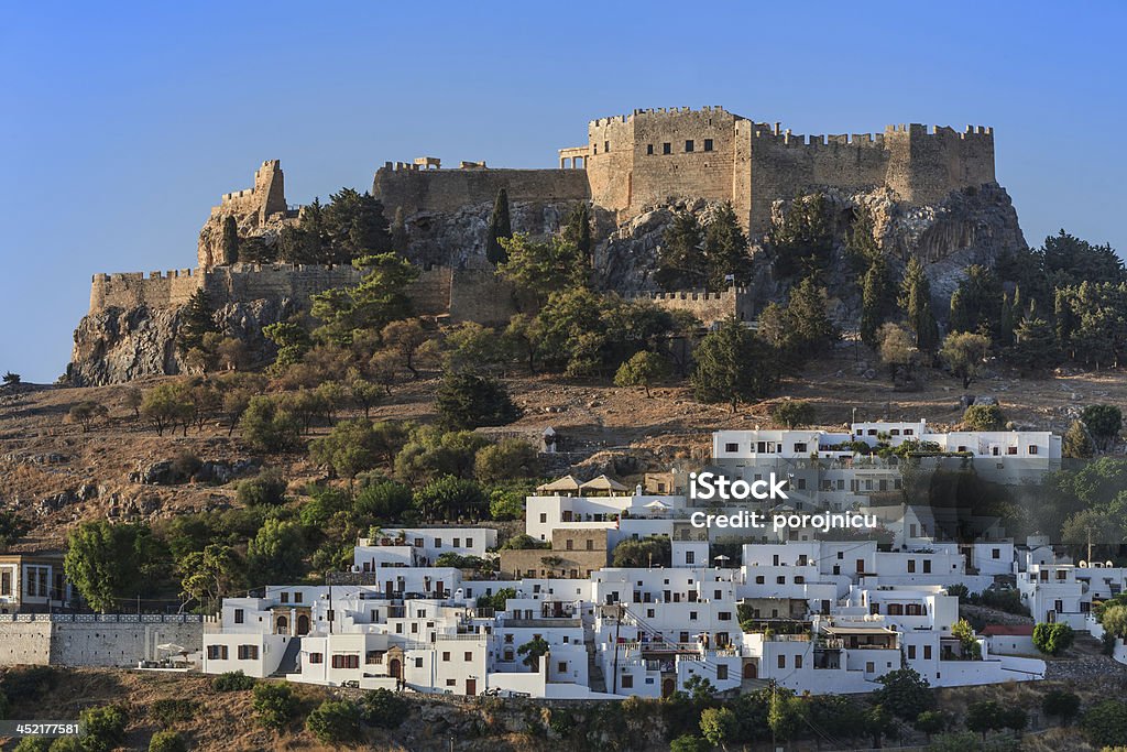 Lindos Castle and village Lindos with the castle above on the Greek Island of Rhodes Blue Stock Photo
