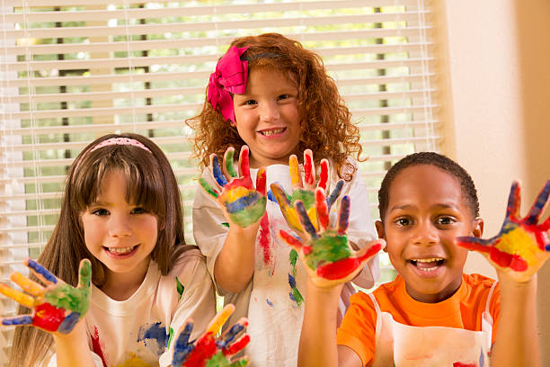 istock Children: Three childhood friends finger painting together. 452192009