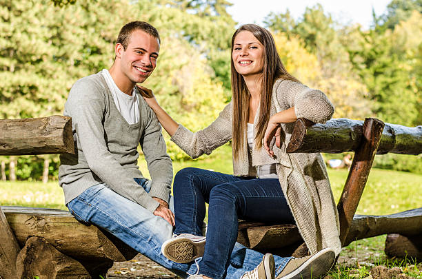 istock Happy young couple on a park bench 452199523