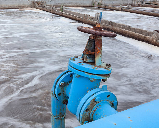 istock Industrial gate valve with blue pipeline into sewage water 452199813