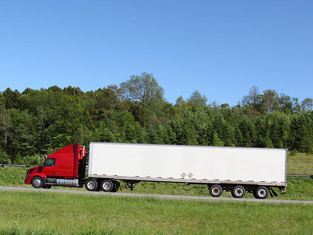 istock Red and white lorry driving through countryside 452199925