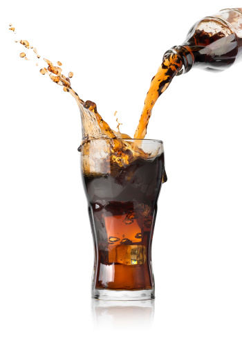 Cola pouring from a bottle into a glass