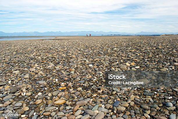 Stoney Spiaggia Con Molto Distante Walkers - Fotografie stock e altre immagini di Angolatura insolita - Angolatura insolita, Composizione orizzontale, Fotografia - Immagine