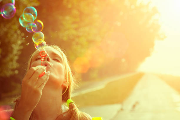 молодая женщина, весело и послать bubbles на открытом воздухе - women autumn teenage girls teenager стоковые фото и изображения