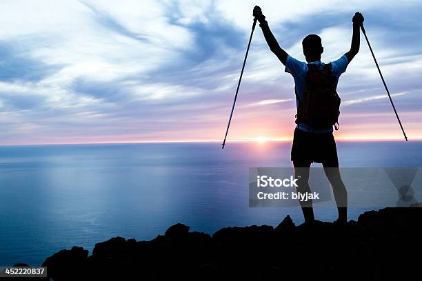 Silhouette Uomo Escursioni In Montagne Oceano E Del Tramonto - Fotografie stock e altre immagini di Braccia tese