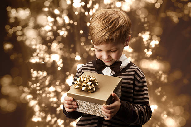 istock Child holding gift box, boy in vintage style. 452221987