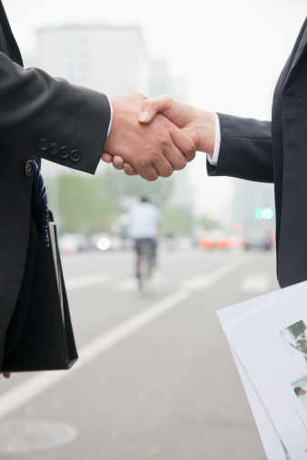 Business People Shaking Hands On Road