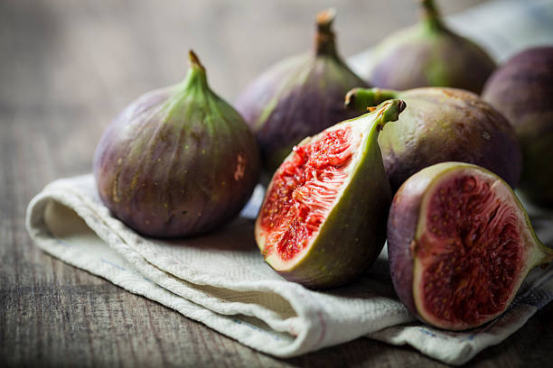 istock Whole and sliced figs on a folded linen on wood table 452232337