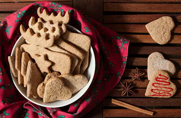 Gingerbreads and winter spices on wooden background