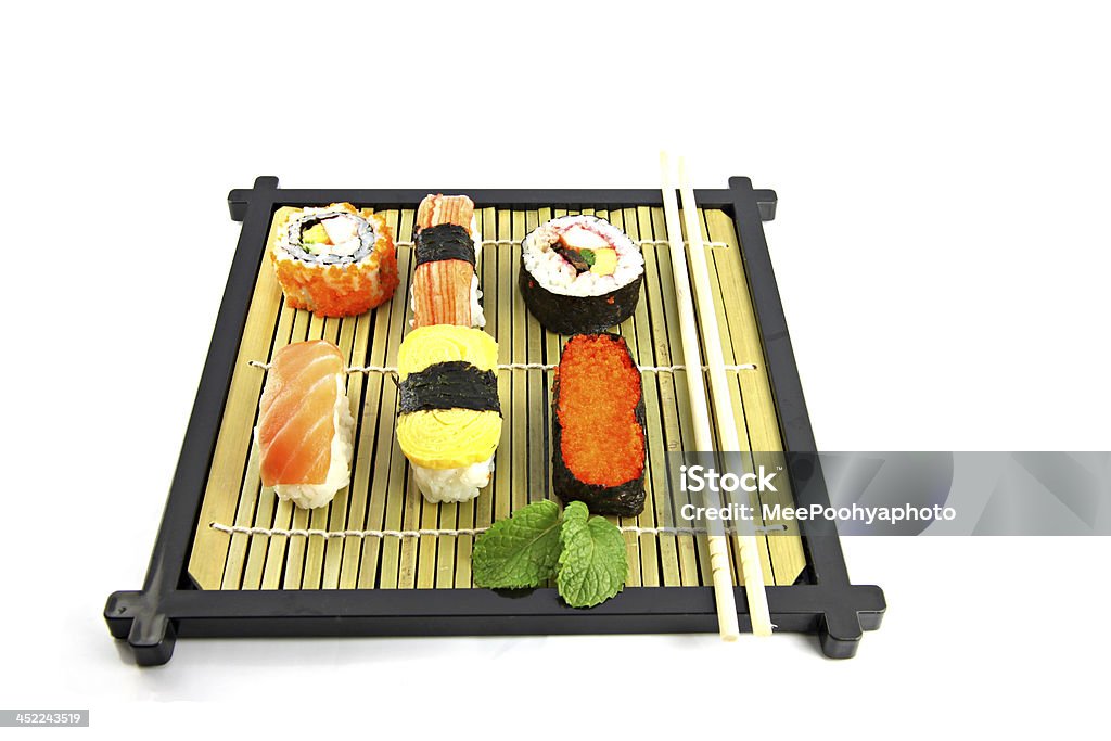 Sushi disporli su un piatto in bambù. - Foto stock royalty-free di Alga