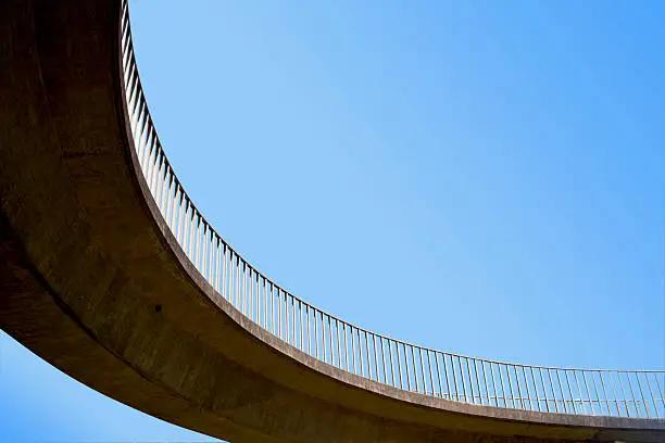 isolated abstract closeup of curved section of overhead pedestrian footbridge and railings