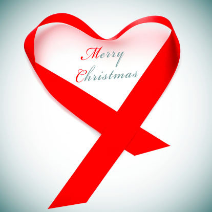 a red satin ribbon forming a heart and the sentence merry christmas