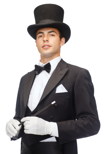 performance, circus, show and people concept - magician in top hat with magic wand 