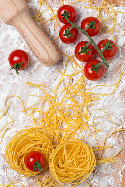 istock Italian egg pasta nest, cherry tomatoes and rolling pin 452252245