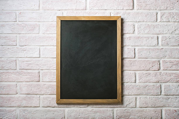 Blank chalkboard with wooden frame on white brick wall Chalk board on a white brick wall writing slate stock pictures, royalty-free photos & images