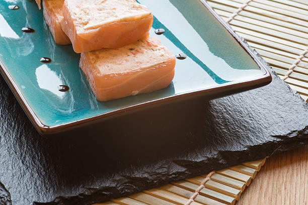 Sushi salmon parcels on dish with chopsticks