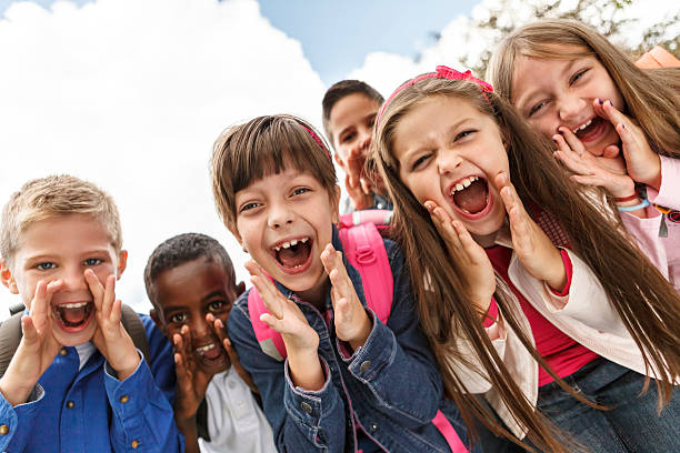 los niños en edad escolar fuera gritar - elementary student child laughing group of people fotografías e imágenes de stock