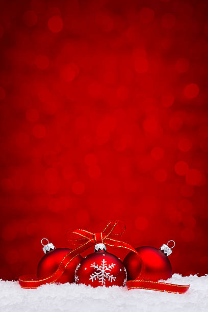 Red bauble withs snowflake decoration lying on snow stock photo