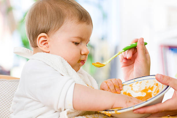 istock Cute messy baby boy playing with food while eating. 452256989